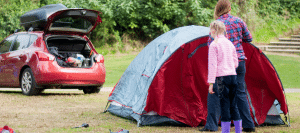 Moreton Bay Expo Camping mum and child putting up red tent in forest next to red car